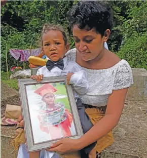  ?? Photo: Wati Talebula ?? Mum Sereana Makasiale with her two-year-old son Junior Mosese holding Malcolm’s picture frame at Lovonilase Cemetery in Suva on February 9, 2019.