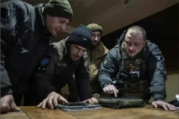  ?? Evgeniy Maloletka/Associated Press ?? A Ukrainian commander of a unit, right, speaks to his comrades during planning for an operation Monday at the front line in Donetsk region, Ukraine.