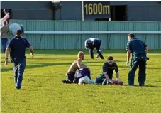  ?? Photo: Kevin Farmer ?? Apprentice Madeleine Wishart is attended to by paramedics after falling from Top Luck after the finish of Saturday’s Three-Year-Old Handicap at Clifford Park.