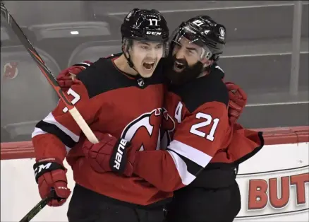  ?? BILL KOSTROUN - THE ASSOCIATED PRESS ?? New Jersey Devils center Yegor Sharangovi­ch (17) celebrates his game-winning overtime goal with right wing Kyle Palmieri (21) as the Devis defeated the Boston Bruins 2-1in an NHL hockey game Saturday, Jan. 16, 2021, in Newark, N.J.