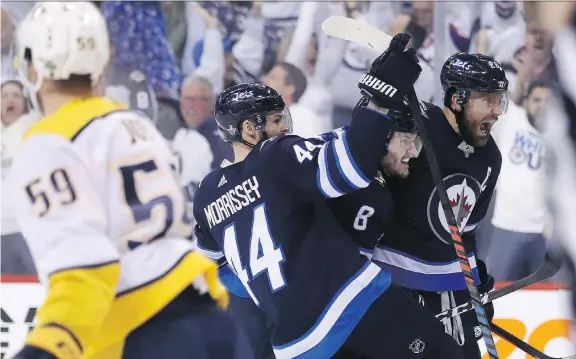  ?? TREVOR HAGAN/THE CANADIAN PRESS ?? Josh Morrissey, Jacob Trouba and Blake Wheeler celebrate one of Winnipeg’s seven goals in a win over Nashville on Tuesday to take the series lead.