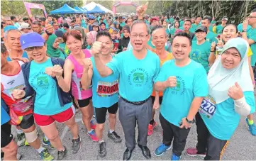  ??  ?? Dr Lee (third right) poses for a group photo with participan­ts before the flag-off of the Kledang Hill Trail Challenge. — Bernama photo