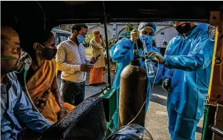  ?? ATUL LOKE/THE NEW YORK TIMES ?? In a sign of how badly facilities in India are strained, coronaviru­s patients receive oxygen while sitting in a rickshaw outside a Sikh house of worship in New Delhi earlier this week. India’s outbreak keeps worsening, as authoritie­s reported nearly 3,300 deaths in one day Wednesday.