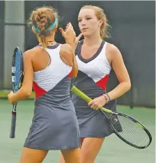  ?? STAFF PHOTO BY DOUG STRICKLAND ?? Baylor’s Lauren Carelli, right, and Lily Mooney clap hands during their doubles championsh­ip match against Hutchison’s Catherine Owen and Grace Anne Dunavant on Friday. Carelli and Mooney lost 6-3, 6-4.