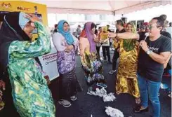  ??  ?? GELAGAT pengunjung berpakaian wanita di gerai #YouCanDuit.