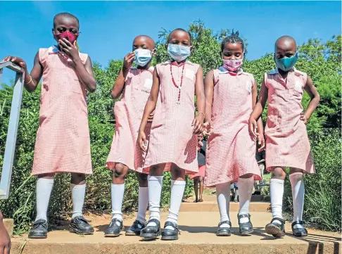  ?? ?? CLASS ACT: Pupils walk around the school compound during breaktime at Kitante Primary School in Kampala.