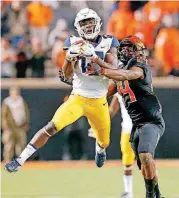  ?? SARAH PHIPPS, THE OKLAHOMAN] [PHOTO BY ?? West Virginia’s Gary Jennings makes a catch in front of OSU’s Jarrick Bernard last week in Stillwater.