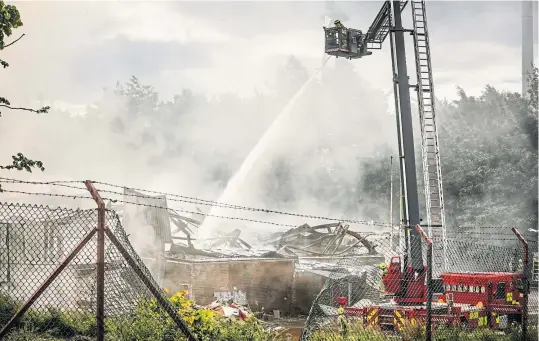  ?? Pictures: Mhairi Edwards. ?? Firefighte­rs continue dampening down the smoulderin­g wreckage yesterday.