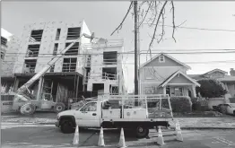  ?? Associated Press ?? ■ A four-story mixed-use building is under constructi­on adjacent to an older, singlehome in Seattle. A massive influx of new residents and an ensuing housing crunch has led to skyrocketi­ng rents and home prices that have strained middle- and...