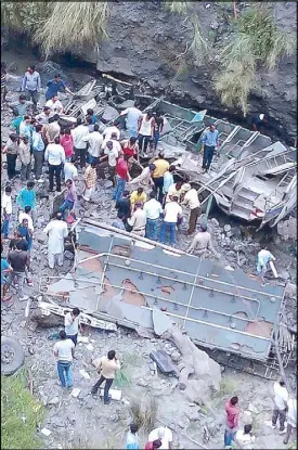  ?? AFP ?? People gather beside the wreckage of a bus which fell into a gorge in India’s northern state of Himachal Pradesh killing 30 on Friday.
