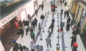  ?? CHRIS HELGREN / REUTERS FILES ?? Shoppers wearing mandatory masks at the Eaton Centre in Toronto two days before
stricter COVID-19 restrictio­ns were introduced in last November.