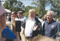  ?? The Associated Press ?? U.S. President Donald Trump visits a neighbourh­ood in Conway, S.C., accompanie­d by South Carolina Gov. Henry McMaster.