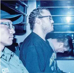  ??  ?? File photo show, Jutting (second left), sitting in a prison van as he arrives at the eastern court in Hong Kong. — AFP photo