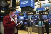  ?? COLIN ZIEMER — NEW YORK STOCK EXCHANGE ?? Trader Ashley Lara, left, works on the floor of the New York Stock Exchange during the Golden Falcon IPO on Friday.