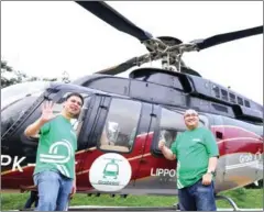  ?? AFP PHOTO/GRAB INDONESIA ?? Ridzki Kramadibra­ta (left), managing director of online ride-hailing firm Grab Indonesia, and Mediko Azwar (right), the company’s marketing director, pose on Friday prior to taking a helicopter taxi operated by Grab Indonesia in Jakarta.