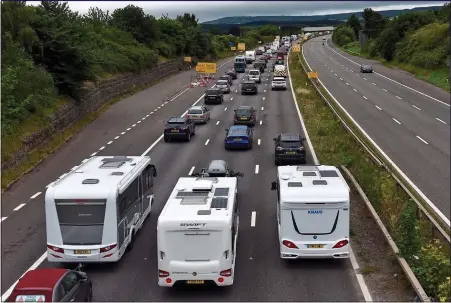  ??  ?? THE GREAT GETAWAY: Drivers of motorhomes and cars find it slow going on the southbound M5 at Exeter
