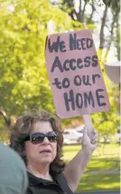  ?? URIEL J. GARCIA THE NEW MEXICAN ?? Diane Quintana holds a sign outside the Santiago E. Campos U.S. Courthouse on Friday in opposition to a judge’s decision in the 51-yearold Aamodt waterright­s case.