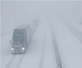  ?? AP ?? SLOW GOING: Traffic creeps along Interstate 70 near Lawrence, Kan., yesterday during heavy snowfall.