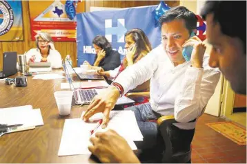  ?? Mark Mulligan / Houston Chronicle ?? State campaign director Carlos Paz Jr. calls a potential voter on Tuesday from Clinton’s Texas headquarte­rs in Houston. Clinton supporters see the Lone Star State as an opportunit­y to slow Sanders’ momentum.