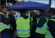  ??  ?? Tentative de médiation mercredi entre l’adjoint au maire Jean-Marc Garnier venu demander aux «gilets jaunes» de se déplacer sur le rond point de la Halte.