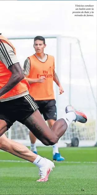  ??  ?? Vinicius conduce un balón ante la presión de Bale y la mirada de James.