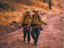  ??  ?? With the community of Mark West Springs just over the ridge from them, firefighte­rs near Windsor keep watch.