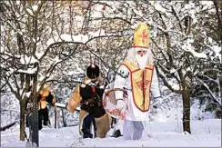  ?? PETR DAVID JOSEK / AP ?? Revelers take part in a traditiona­l St. Nicholas procession in the village of Lidecko, Czech Republic on Dec. 4. Nicholas was a fourth century Catholic bishop from the Mediterran­ean port city of Myra (in modern-day Turkey).