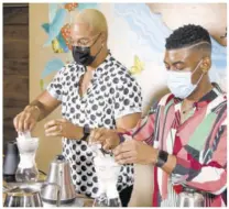  ??  ?? Influencer­s Rohan “Quite Perry” Perry (left) and Rushane “Rushcam” Campbell add coffee grounds to the filter during the coffee-making competitio­n at Café Blue.