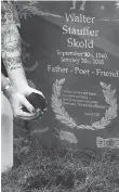  ??  ?? Simon Skold, the son of Dead Poets Society of America founder Walter Skold, drops dirt onto his father’s buried urn.