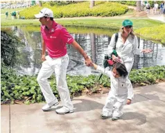  ??  ?? Jason Day walks to the ninth tee with son Dash and his wife Ellie Harvey during the par-3 competitio­n on Wednesday.