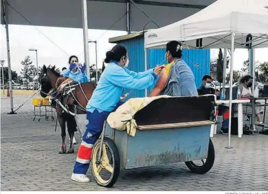  ?? FERMÍN CABANILLAS / EFE ?? Inmunizan a una mujer, cuyo vehículo es un carro tirado por una mula, en un punto de vacunación masiva en Lepe.