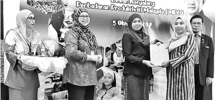  ??  ?? Dayang Monalizawa­ti (second right) presents the SKM-PPT certificat­e to one of the trainees.