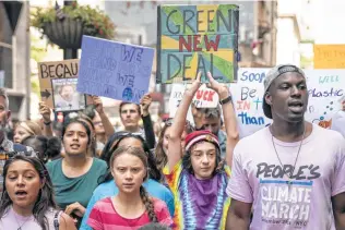  ?? Drew Angerer / Getty Images ?? Swedish climate activist Greta Thunberg, second from left, leads young activists and their supporters in a march Friday in New York City for action on climate change.