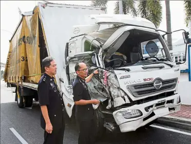  ??  ?? Damaged: ACP Mohammad Azlin (right) and deputy OCPd supt Lee swee Meng showing the damaged lorry driven by the teenager in subang Jaya.