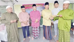  ??  ?? Sapawi intongan di Ahmad om Hafez papatahak do tusin zakat tinimungan ‘asnaf’ kumaa lansanon Imam id masjid dilo.