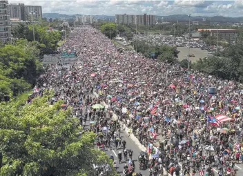  ?? Joe Raedle / Getty Images ?? Thousands fill the Expreso Las Américas highway in San Juan, Puerto Rico, to call for the resignatio­n of Gov. Ricardo Rosselló. A slogan calling for his resignatio­n, “Ricky Renuncia,” was found everywhere there.