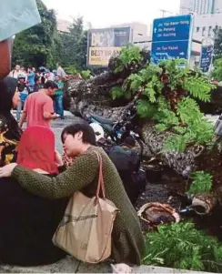  ??  ?? ORANG awam menenangka­n mangsa wanita yang terkejut.