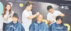  ??  ?? KELAI KEREJASAMA: Sekeda sida ke bisi datai ngulu program `Go Bald 2018’ benung digundul raban volunteer ari O2 Hair Style.