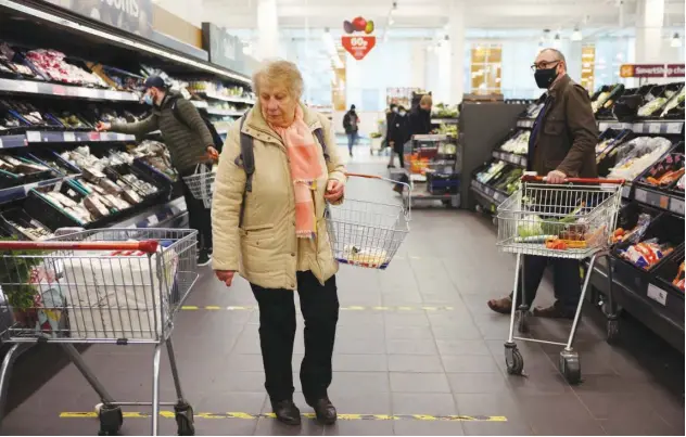  ?? File/reuters ?? ↑ Shoppers at a supermarke­t in London.