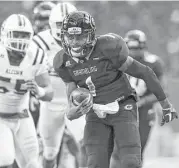  ??  ?? Grambling State quarterbac­k Devante Kincade, who accounted for four scores, heads toward the end zone for one of his two rushing touchdowns.