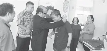  ??  ?? KENANG: Pastor Joseph (tiga kiba) nyuaka tepa ngagai Dr Annuar.