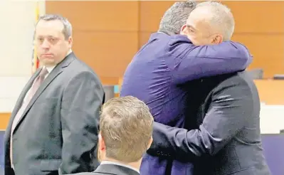  ?? MIKE STOCKER/SUN SENTINEL ?? Andrew Pollack, the father of Meadow Pollack, one of those killed in the Parkland shooting, hugs his lawyer, David Brill, on Wednesday before a hearing regarding former Broward sheriff’s Deputy Scot Peterson.