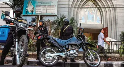  ?? REZA MANGANTAR/MANADO POST/JPG ?? WASPADA: Polisi menjaga ketat Gereja Katedral Hati Tersuci Maria, Manado, kemarin. Sejumlah kota juga siaga pasca pengeboman di Surabaya.