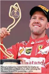  ?? AFPPIX ?? Ferrari’s Sebastian Vettel holds his trophy as he celebrates on the podium after winning the Monaco Grand Prix yesterday. –