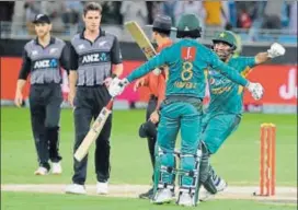  ?? AFP ?? Mohammed Hafeez (left) and Sarfraz Ahmed celebrate after Pakistan beat New Zealand by six wickets in the second T20 at the Dubai Cricket Stadium on Friday.