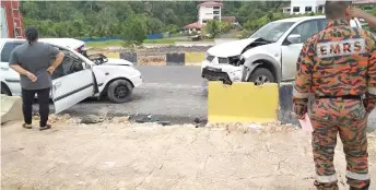  ??  ?? A firefighte­r monitors the site of the accident at Jalan Oya.