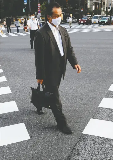  ?? Kim Kyu ng- Hoo n / reut ers fil es ?? People wearing protective masks make their way during the COVID-19 pandemic
at a business district in Tokyo.