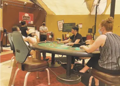  ?? Photos by Rusty Simmons / The Chronicle ?? With a watchful floor assistant assuring proper social distancing, above, gamblers play baccarat Sunday in an outdoor cardroom at Stars Casino in Tracy, which could provide a model for other casinos to reopen.