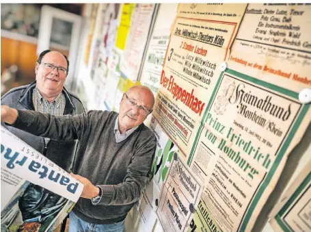  ?? FOTO: RALPH MATZERATH ?? Bodo Esser (l.) und Klaus Peters vom Heimatbund Monheim haben die Plakate für die Ausstellun­g im Deusser-Haus ausgewählt.