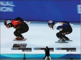  ?? ZHANG WEI / CHINA DAILY ?? Workers pass a huge screen using high-definition light-emitting diode technology at the media center for the Games.